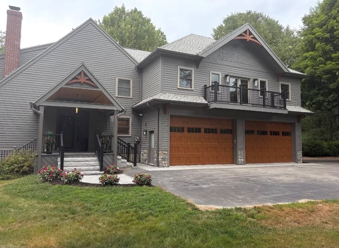 Garage addition with cedar carriage doors and a second-floor balcony